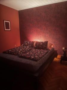 TiszaderzsFerienhaus am Theiß-See Bella的一间卧室配有一张红色墙壁的床