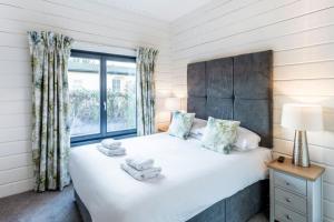 罗伊登Roydon Marina - Lodge 1 - Hot Tub的一间卧室设有一张床和一个窗口