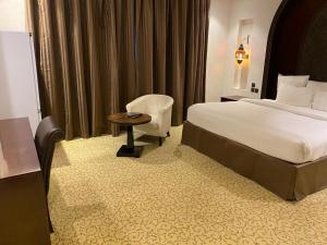 麦纳麦Ista Suites Seef的配有一张床和一把椅子的酒店客房