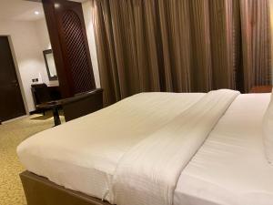 麦纳麦Ista Suites Seef的一张大白色的床,位于酒店客房内