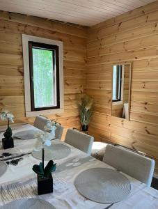 NurmijärviKodikas mökki lähellä luontoa Nurmijärven Perttulassa的一间带桌椅和窗户的用餐室