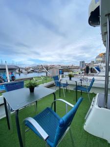 希洪Experiencia en el mar Gijon C的阳台配有桌椅,享有海港的景致。