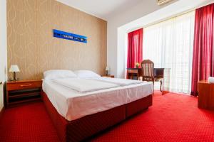 奥西耶克Pansion Strossmayer的一间卧室配有一张大床,铺有红地毯