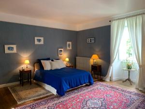 MortemartMaison d'Hôtes de l'Ancien Couvent des Carmes的一间卧室设有蓝色的床和窗户。