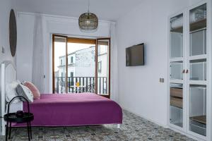 萨莱诺Edahouse的一间带紫色床的卧室和一个阳台