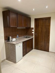 杰津鸢尾花酒店的厨房配有木制橱柜和白色冰箱。