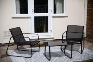 伍尔弗汉普顿Probert- Perfectly Placed- Driveway - 3 bed的两把黑椅子和一张桌子在房子前面