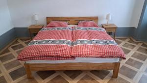 Saint-ImierAppartement de vacances Les Jardins的一张带红白毯子和枕头的床