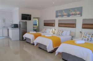 吕德里茨Shark Island Guesthouse的酒店客房设有三张床和厨房