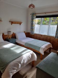 珀斯河滨小屋的一间卧室设有两张床和窗户。
