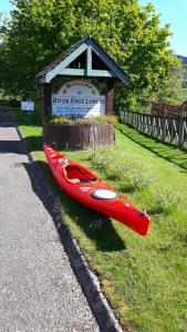 珀斯河滨小屋的红皮艇在草地上,靠近标志