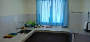 波德申PD Corus myHoliday Homes & Apartments的厨房配有水槽和蓝色窗帘
