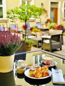 克拉科夫大都会精品酒店的一张桌子,上面放着两盘糕点和咖啡