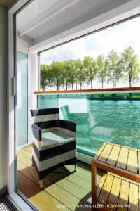 杜塞尔多夫KD Hotelship Düsseldorf Comfort Plus的阳台配有椅子、桌子和窗户。