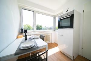 诺伊斯Apartment - Central with kitchen - Balcony - Fair的厨房设有大窗户和白色冰箱。