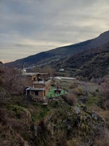 特雷韦莱斯Casa Rural Cortijo Molino Altero的田野上山顶的房子