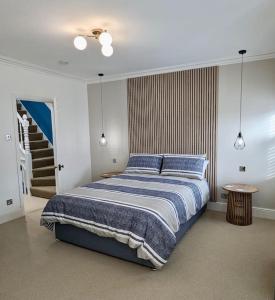 谢林汉姆Happy Place, Sheringham Stunner - Crabpot Cottages Sheringham的一间卧室配有一张带蓝色毯子的大床