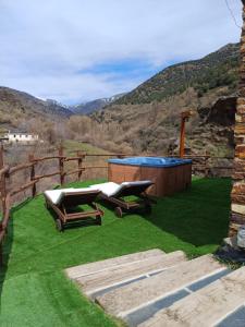 特雷韦莱斯Casa Rural Cortijo Molino Altero的后院设有热水浴池和草地上的椅子