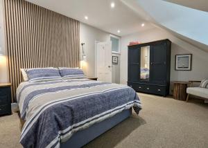 谢林汉姆Happy Place, Sheringham Stunner - Crabpot Cottages Sheringham的一间卧室配有一张大床和一个梳妆台