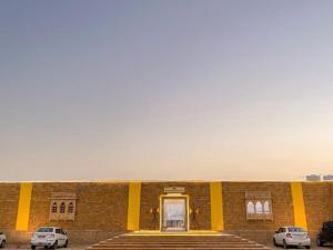 斋沙默尔Royal Luxury Camp Jaisalmer的两辆车停在大楼前的建筑物