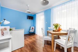 加茨比亚格拉Oliwia的一间拥有蓝色墙壁和桌椅的用餐室