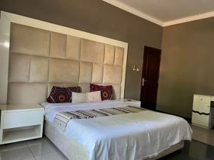 MatolaMATOLA AcCOMMODATION的卧室配有带红色枕头的大型白色床