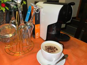 MatolaMATOLA AcCOMMODATION的咖啡壶旁边的桌子上一杯咖啡