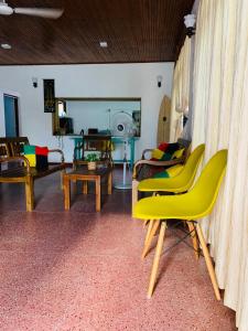 尼甘布Ceylon Glory Hostel的客厅配有黄色椅子和桌子