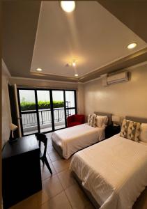 KababaeTrillo Bay Villas的酒店客房设有两张床和一个阳台。