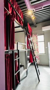 雅典Iconic Athens Hostel的一间设有两张双层床的客房,配有红色衣服
