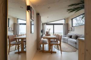 韦斯特卡佩勒Hello Zeeland - Tiny House Zeeuwse Liefde 11的用餐室以及带桌椅的起居室。