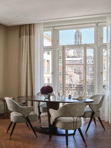 维也纳Rosewood Vienna的一间带桌椅和窗户的用餐室