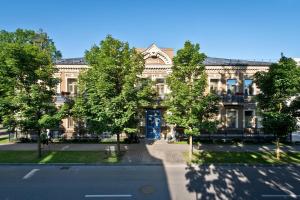德鲁斯基宁凯BEST BALTIC Hotel Druskininkai Central的街道前方树木繁茂的大建筑