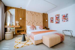 达赫拉TIMAZIN HOTEL DAKHLA的一间卧室配有一张特大号床和一张凳子