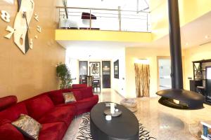 Viñaixa5 bedrooms villa with private pool sauna and terrace at Vinaixa的客厅配有红色的沙发和桌子