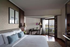 曼谷曼谷河畔安纳塔拉度假酒店的卧室配有一张白色大床和一张书桌