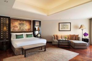 曼谷曼谷河畔安纳塔拉度假酒店的一间卧室配有一张大床和一张沙发
