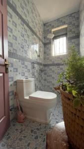 恩德培Kitiko residence Hotel的一间带白色卫生间的浴室和窗户。