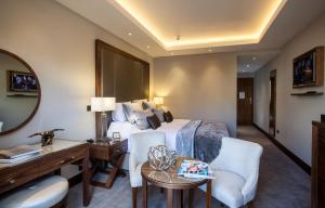 皇家滕布里奇韦尔斯壹华威公园酒店的酒店客房,配有一张床、一张桌子和椅子