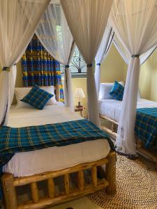 恩德培Kitiko residence Hotel的一间卧室配有两张床、窗帘和窗户