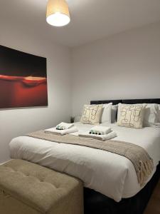 格洛斯特3 Bed Chill Glouc的卧室配有一张带白色床单和枕头的大床。