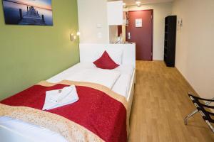 布达佩斯迪威尔第公寓酒店 的卧室配有一张带红色毯子的白色床
