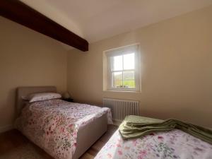 巴林托伊Dunnaglea Cottage, Ballintoy的一间卧室设有两张床和窗户。