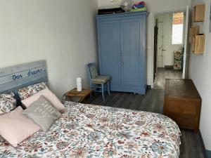 迪耶普LES BAIGNEUSES的一间卧室配有一张床和一个蓝色的橱柜