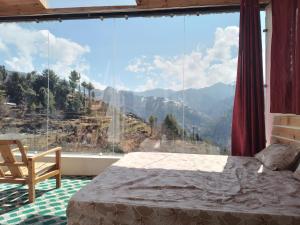 马恩迪Stargazing Glass Lodge Himachal Pradesh Thachi的卧室设有山景大窗户