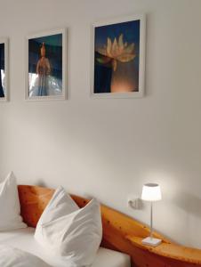 雷丹尼茨恩Lorenzhof by JULKA - self checkin的卧室配有一张床,墙上挂有两张照片