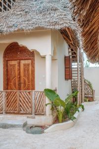 江比阿Marvelous Zanzibar的一座带木门和门廊的房子