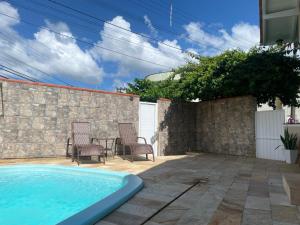 布卢梅瑙Blumen Espaço "piscina privativa'的后院的游泳池,配有两把椅子和一张桌子
