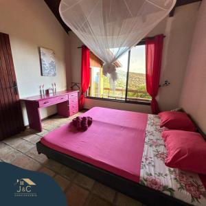 莱昂斯-达赫雷La Villa de Petite Anse - Piscine的卧室配有一张大粉色床和窗户