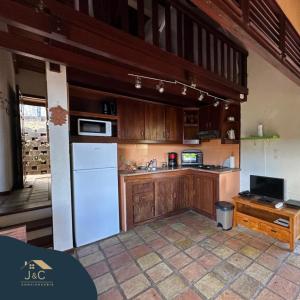 莱昂斯-达赫雷La Villa de Petite Anse - Piscine的厨房配有木制橱柜和白色冰箱。